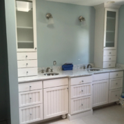 Bright, modern bathroom with white cabinetry and dual sinks.